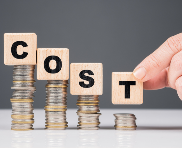 積み上げたコインの上に COST の文字ブロックが並び、右端のブロックだけコインが少なく低くなっている写真。費用を抑えるイメージ